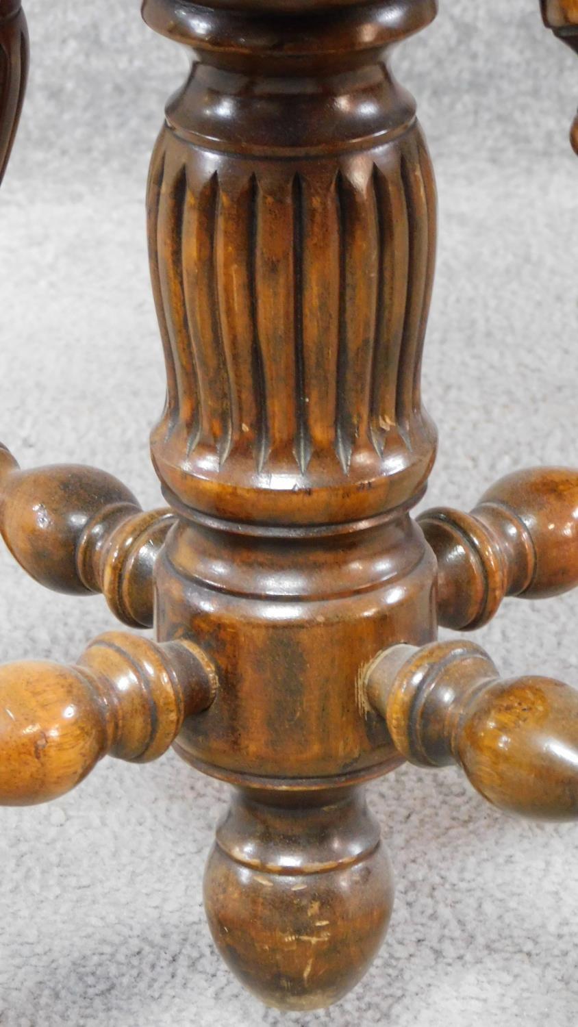 A Victorian walnut revolving piano stool with foliate carving to the back on reeded stretchered - Image 8 of 14