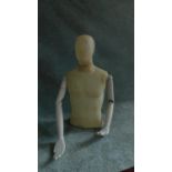 A moulded male mannequin, head and torso with articulated arms. H.80cm