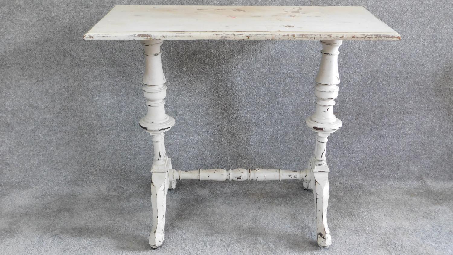 A 19th century distressed painted centre table on turned stretchered supports. H.70 W.86 D.42cm