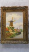 Ignatius Moogland (1889-1974), a gilt framed oil on canvas, windmill by a canal, signed. 81x61cm