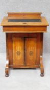 A late Victorian walnut and inlaid Davenport fitted central cupboard doors on bun feet. H.75 W.217