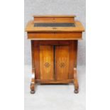 A late Victorian walnut and inlaid Davenport fitted central cupboard doors on bun feet. H.75 W.217