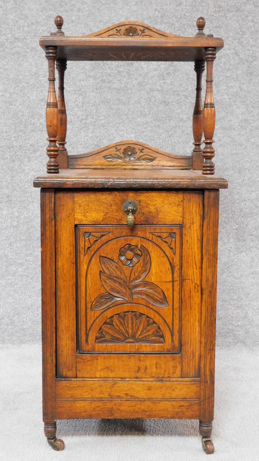 A Victorian oak coal purdonium with carved floral fall front revealing coal compartment. H.97 W.39