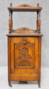 A Victorian oak coal purdonium with carved floral fall front revealing coal compartment. H.97 W.39