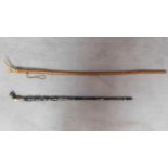 Two canes. One with head form top and entire cane carved from animal horn with brass banding and