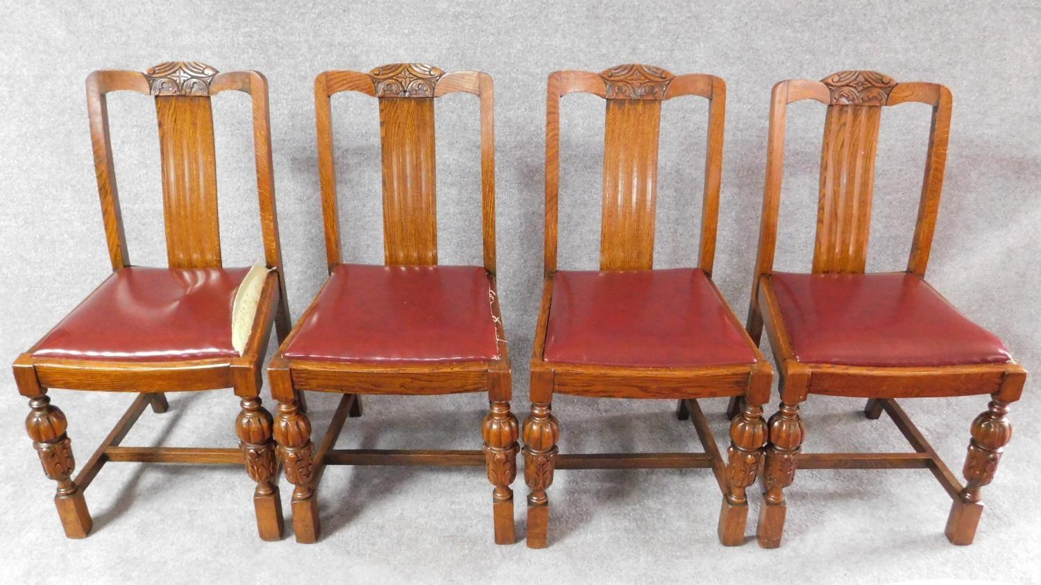 A set of four mid 20th century oak dining chairs with carved cresting in the Jacobean style. H.87cm