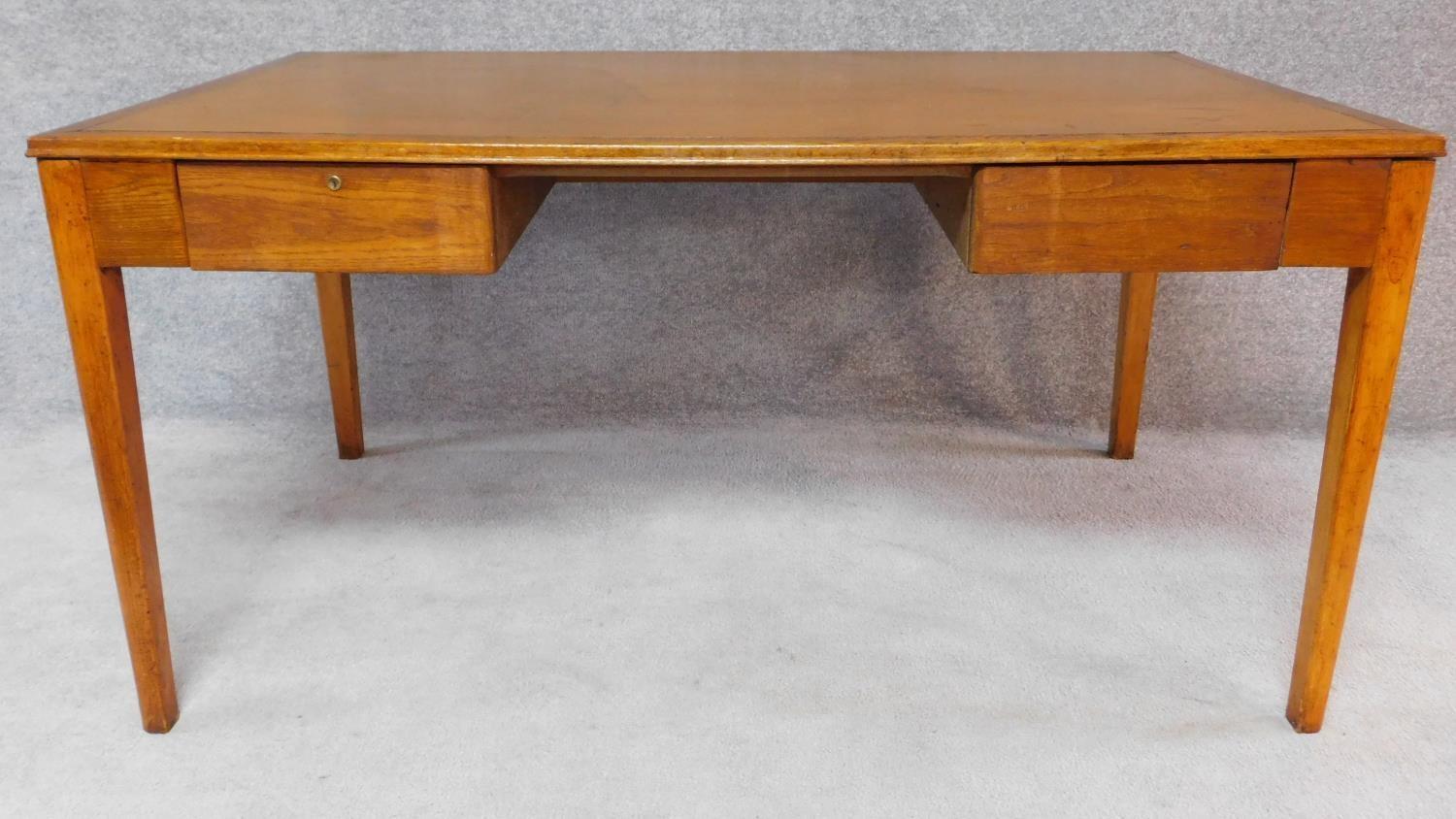 A mid 20th century oak two drawer writing table. H.76 W.152 D.91cm