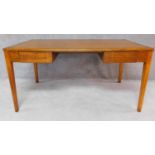 A mid 20th century oak two drawer writing table. H.76 W.152 D.91cm
