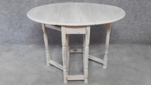 A small painted drop flap dining table with gateleg action. H.66 W.97 D.81cm