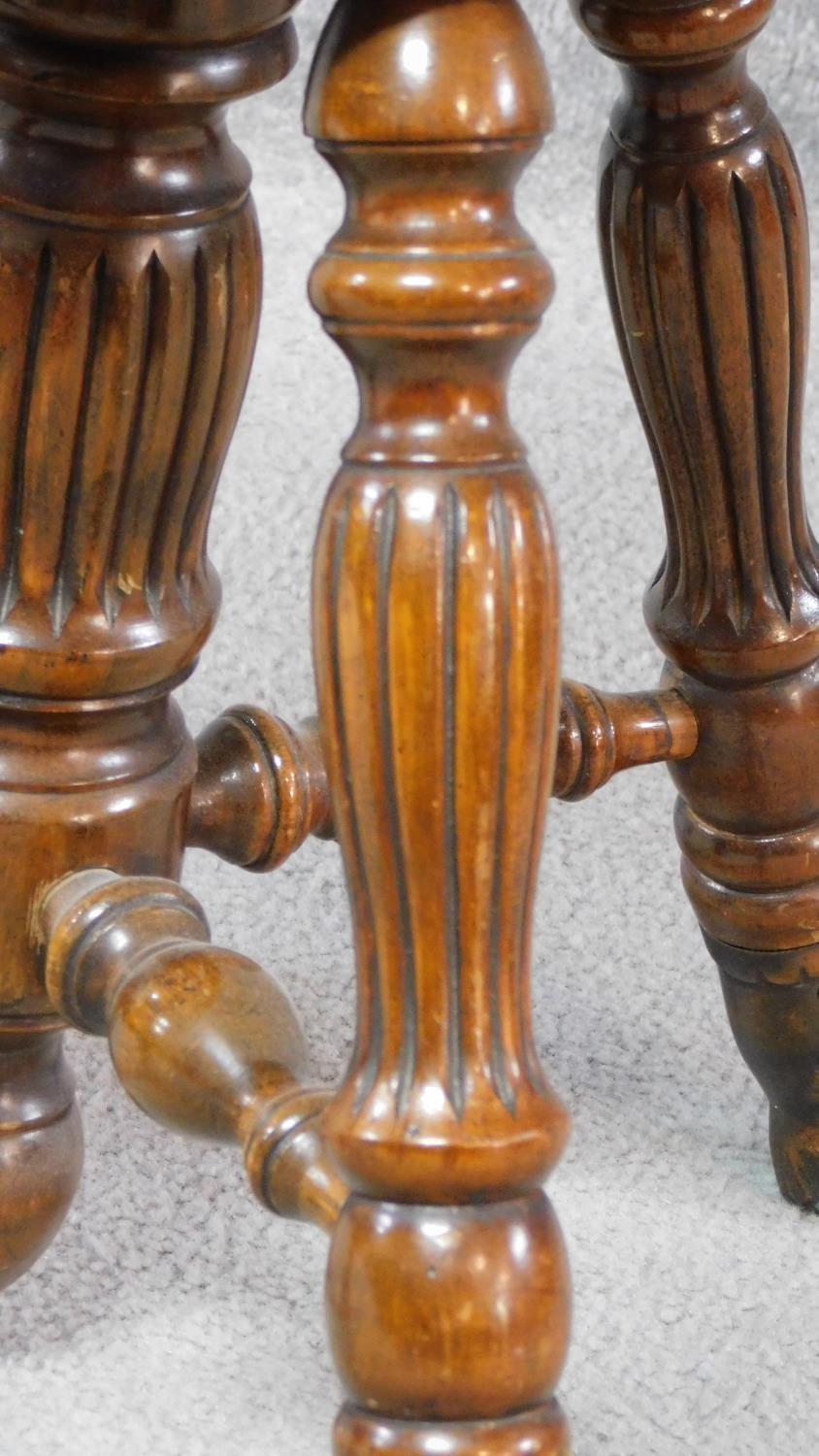 A Victorian walnut revolving piano stool with foliate carving to the back on reeded stretchered - Image 9 of 14