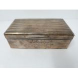 A silver cigarette box, cedar lined, London 1922, Alex Clark Ltd, inscribed with dedication.