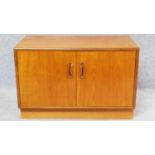 A mid 20th century teak two door cabinet by G-Plan, label to door. H.54 W.81 D.46cm