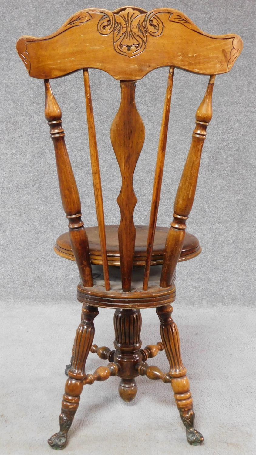 A Victorian walnut revolving piano stool with foliate carving to the back on reeded stretchered - Image 13 of 14