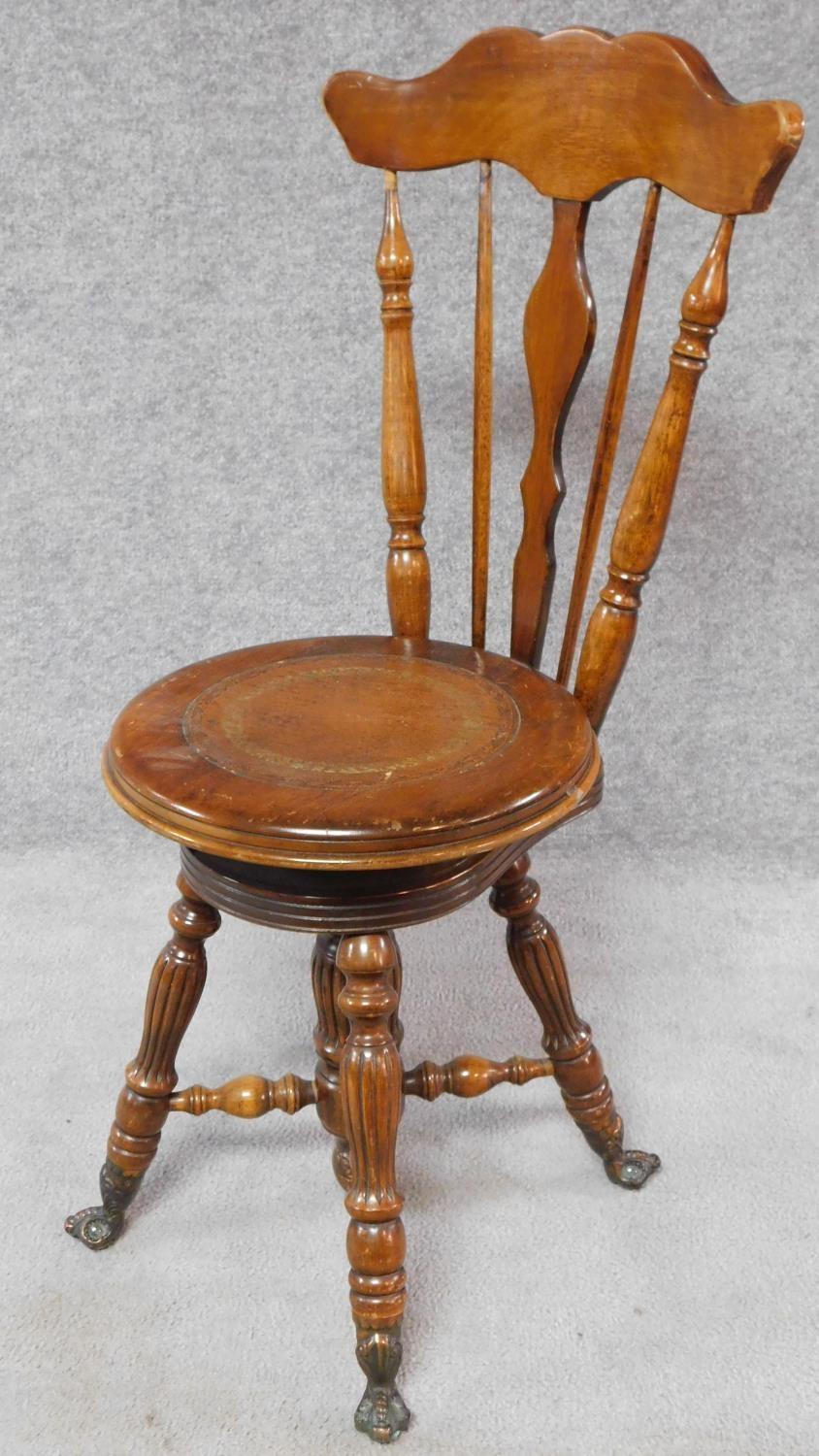 A Victorian walnut revolving piano stool with foliate carving to the back on reeded stretchered - Image 2 of 14