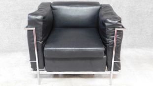 A black faux leather upholstered Le Corbusier style armchair with chrome tubular frame. H.72 W.90