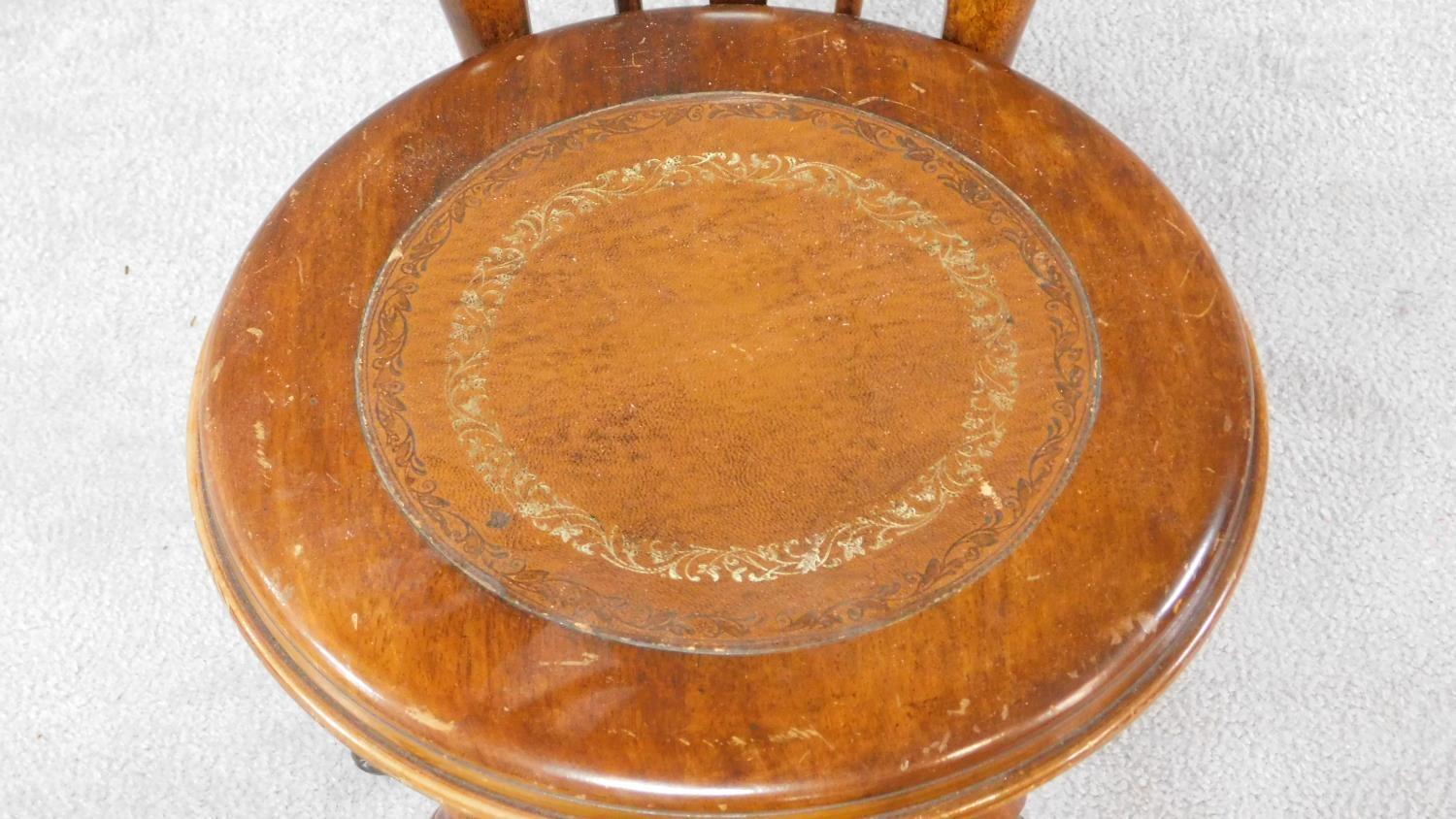 A Victorian walnut revolving piano stool with foliate carving to the back on reeded stretchered - Image 5 of 14