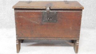 A small antique oak plank coffer with original hinges, clasp and lock with dentil carved top and