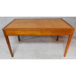 A mid 20th century oak writing table on square tapering supports. H.76 W.136 D.76cm