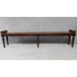 A Regency mahogany long window seat with scroll baton ends on turned tapering supports. H.51 W.215