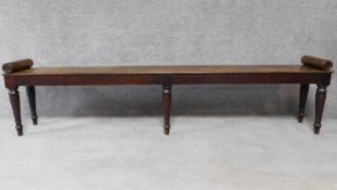 A Regency mahogany long window seat with scroll baton ends on turned tapering supports. H.51 W.215