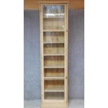 A tall pine bookcase with glazed door and fitted with eight shelves. H.243cm