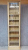 A tall pine bookcase with glazed door and fitted with eight shelves. H.243cm