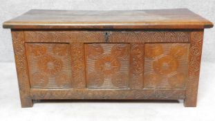 An antique oak coffer with carved frieze and panels fitted candle box on block feet. H.61 W.133 D.