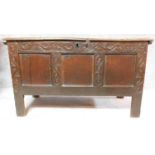 A 17th century panelled oak coffer with carved frieze on block feet. H.63 W.108 D.48cm