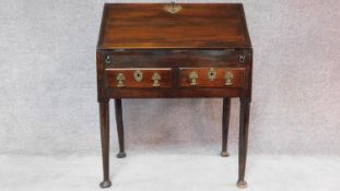 A Georgian mahogany bureau with fitted interior above two drawers with original handles on