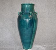 A large green drip glazed sharab wine vessel with six handles. H.94cm