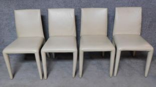 A set of four leather covered dining chairs. H.84cm