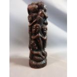 A carved African hardwood tree of life statue with carved tribal figures. H 32cm.