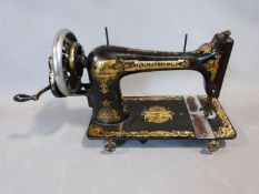 An antique Singer sewing machine with Sphinx", or "Memphis" gold foil motifs. H27 x L46