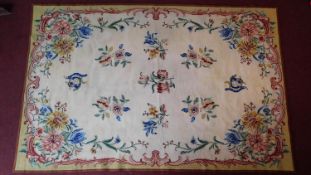 A tapestry style hand knotted carpet with allover floral design within Rococo scroll borders.