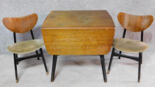 A mid 20th century teak drop flap dining table with ebonised base and a pair of matching dining