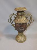 A large Oriental brass two handled urn with relief decoration and foliate form handles. Height 58cm.