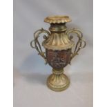 A large Oriental brass two handled urn with relief decoration and foliate form handles. Height 58cm.