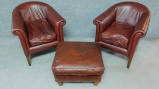 A pair of contemporary tan leather tub armchairs on square tapering supports together with a