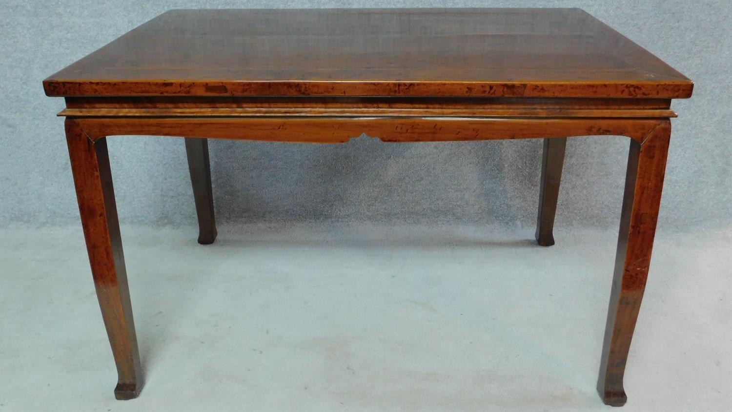 A Chinese teak centre table on shaped tapering square section supports. H.87 W.135 D.89cm