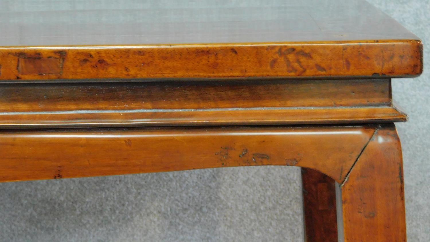 A Chinese teak centre table on shaped tapering square section supports. H.87 W.135 D.89cm - Image 2 of 5