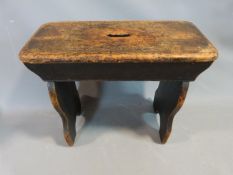 A 19th century stained pine milking stool. 58 cm L, 26cm D and 47 H.