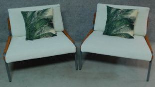 A pair of metal framed and wicker easy chairs with ivory fabric upholstery. H.72 W.92 D.80cm