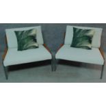 A pair of metal framed and wicker easy chairs with ivory fabric upholstery. H.72 W.92 D.80cm