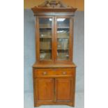 A Victorian walnut two section library bookcase with upper glazed section above panel doors and well