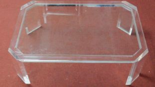 A perspex coffee table with shaped drop in glass top. H.39 W.120 D.79cm