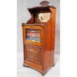 A late Victorian walnut music cabinet with fitted shelved interior containing various volumes of