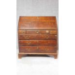 A Georgian oak bureau with fall front revealing fitted interior above three short and three long