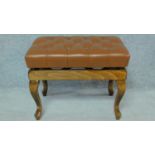 A buttoned leather adjustable piano stool on cabriole supports. H.45 W.65 D.41cm
