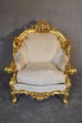 A heavily carved giltwood Baroque style armchair in floral damask. H.110 x 69cm