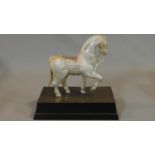 An indian metal mounted figure of a horse on a wooden stand with engraved detailing. Stamped to
